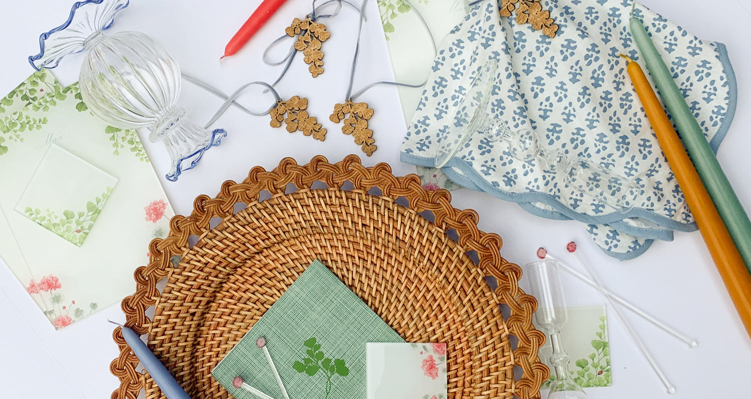 Table top decor elements including rattan charger, candles, ruffled vase, acrylic menus and place cards, wooden napkin charms and acrylic ladybug stir sticks