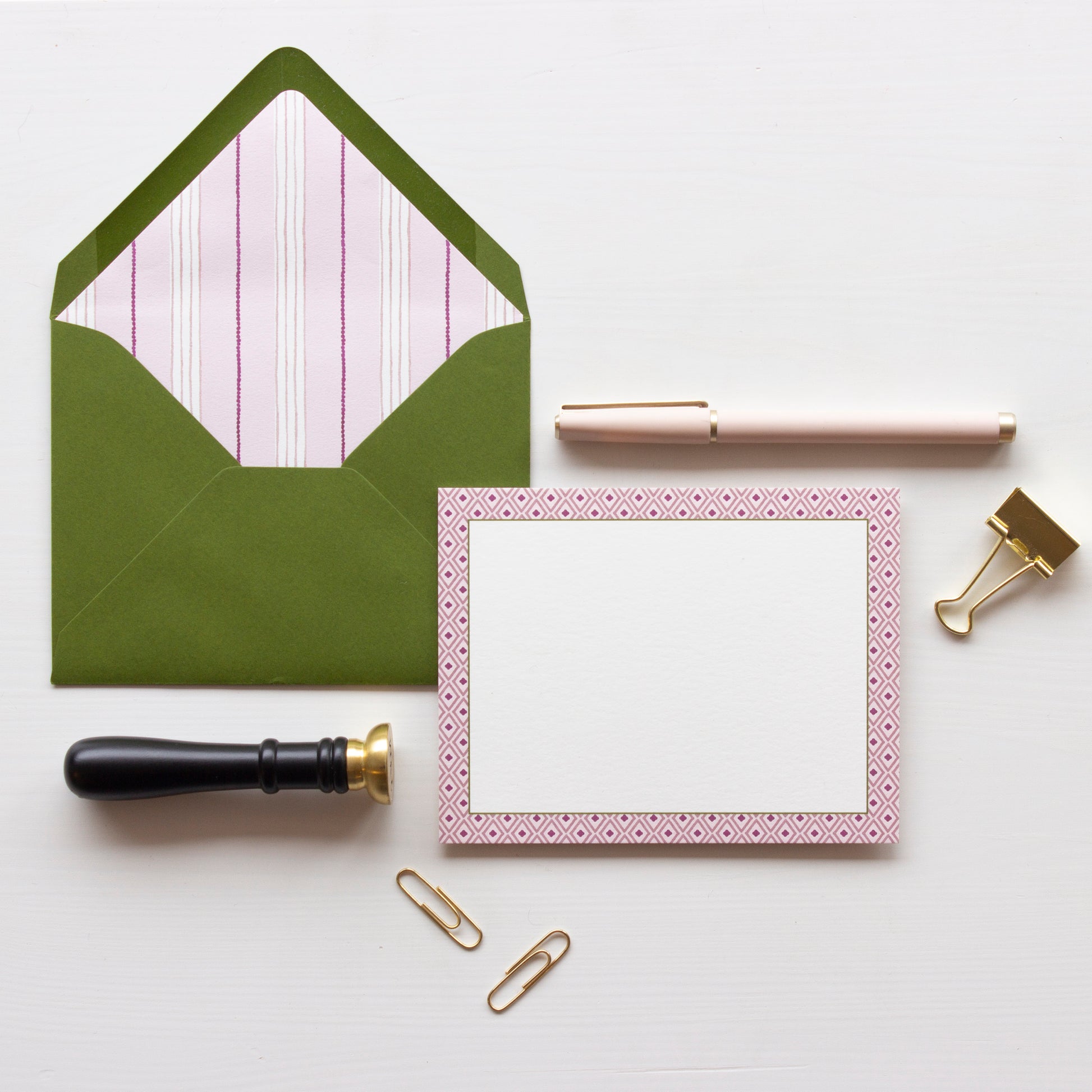 White notecard with geometric light pink and magenta diamond border. Olive green envelope lined with light pink, white and olive pin stripes.